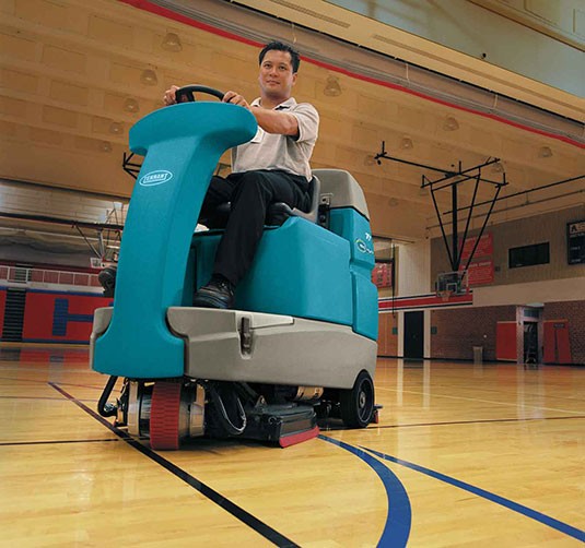 Fregadora de suelo de conductor sentado T7+ limpiando un gimnasio